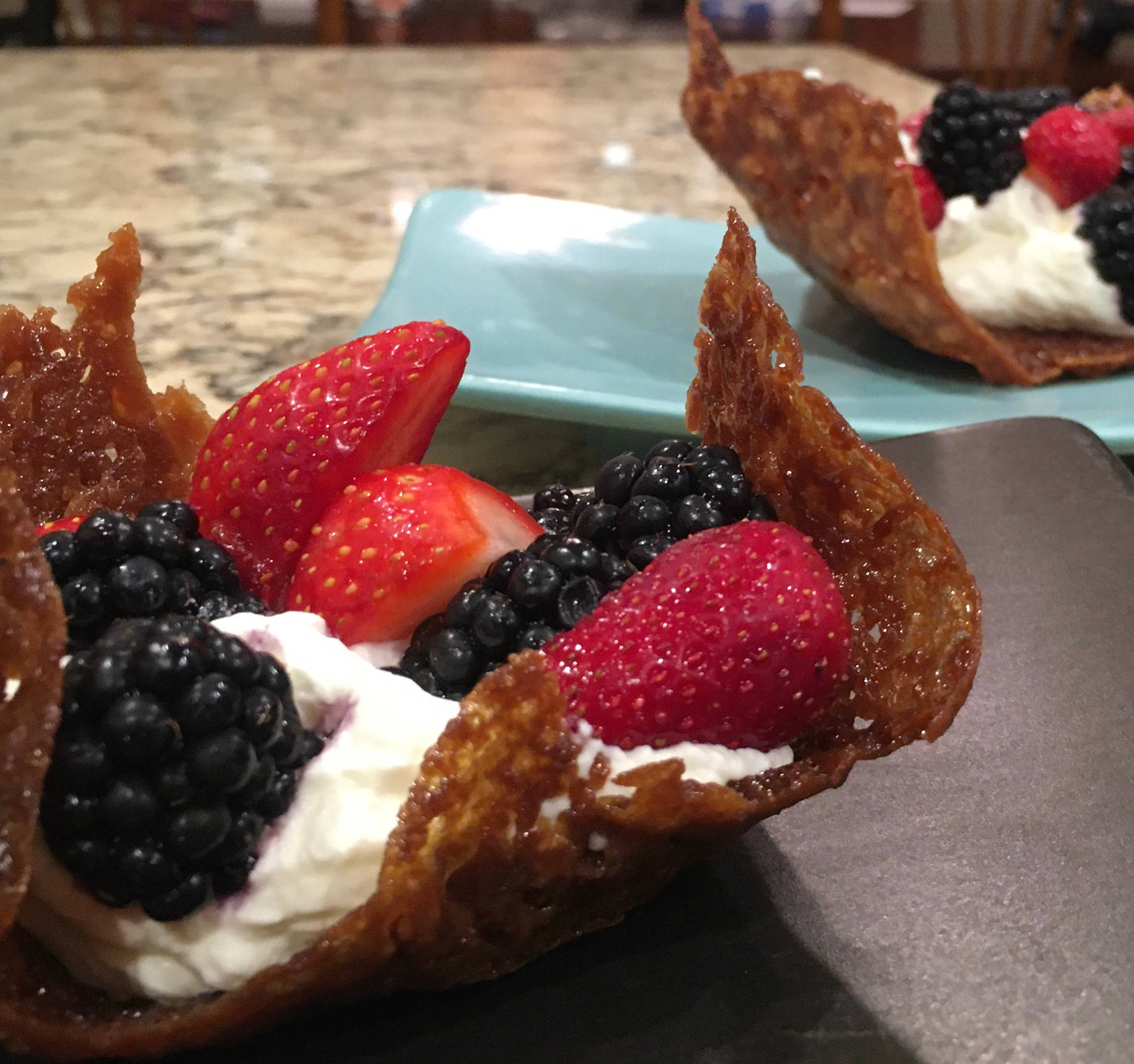 The finished brandy snaps, served with cream and fruit