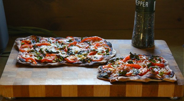 Homemade pizza sitting on a chopping board